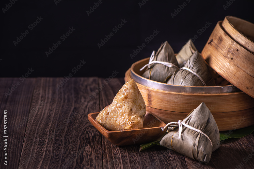 Rice dumpling, zongzi - Bunch of Chinese traditional cooked food on wooden table over black backgrou