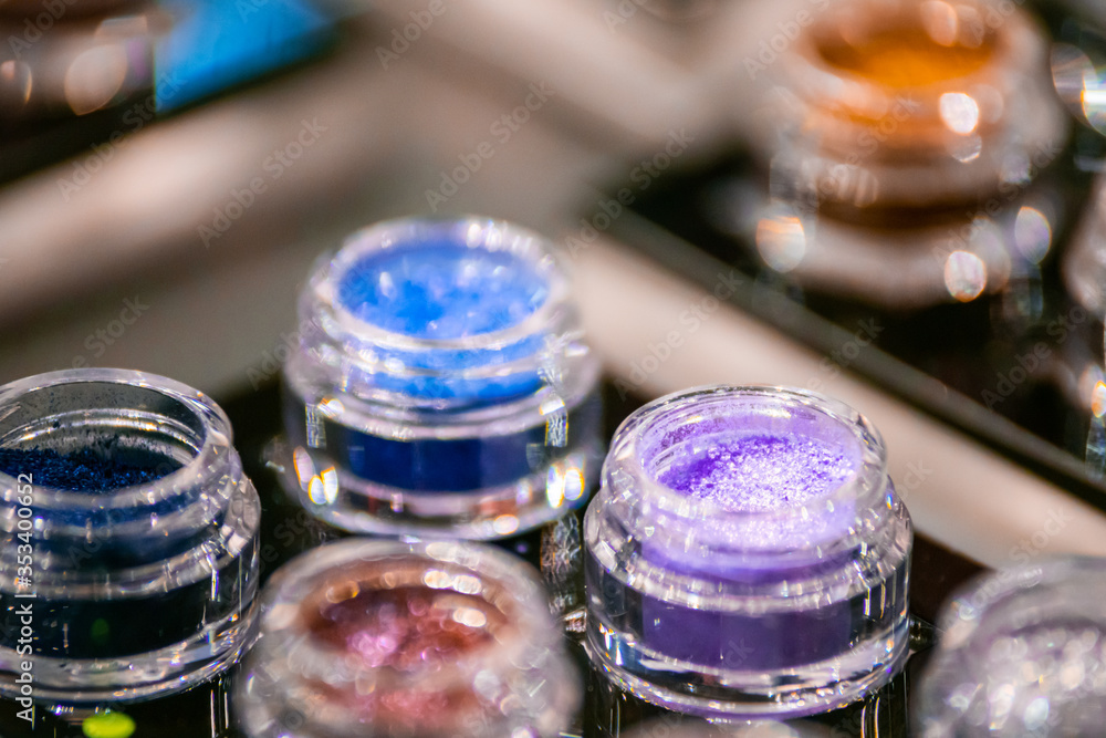 Colorful nail glitters in tubes on beauty store exhibition