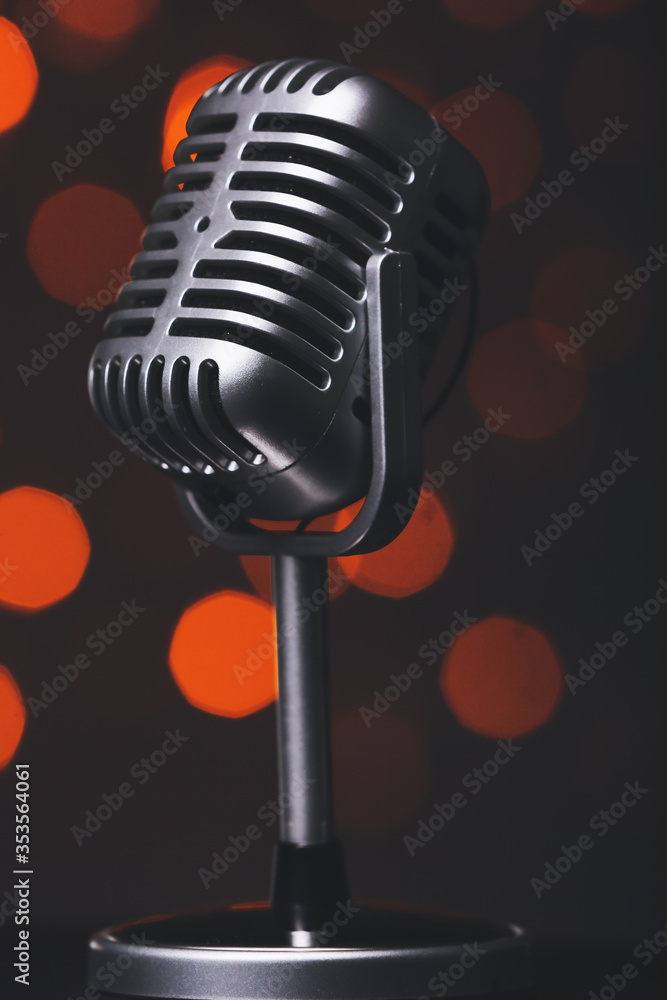 Retro microphone on dark background with blurred lights