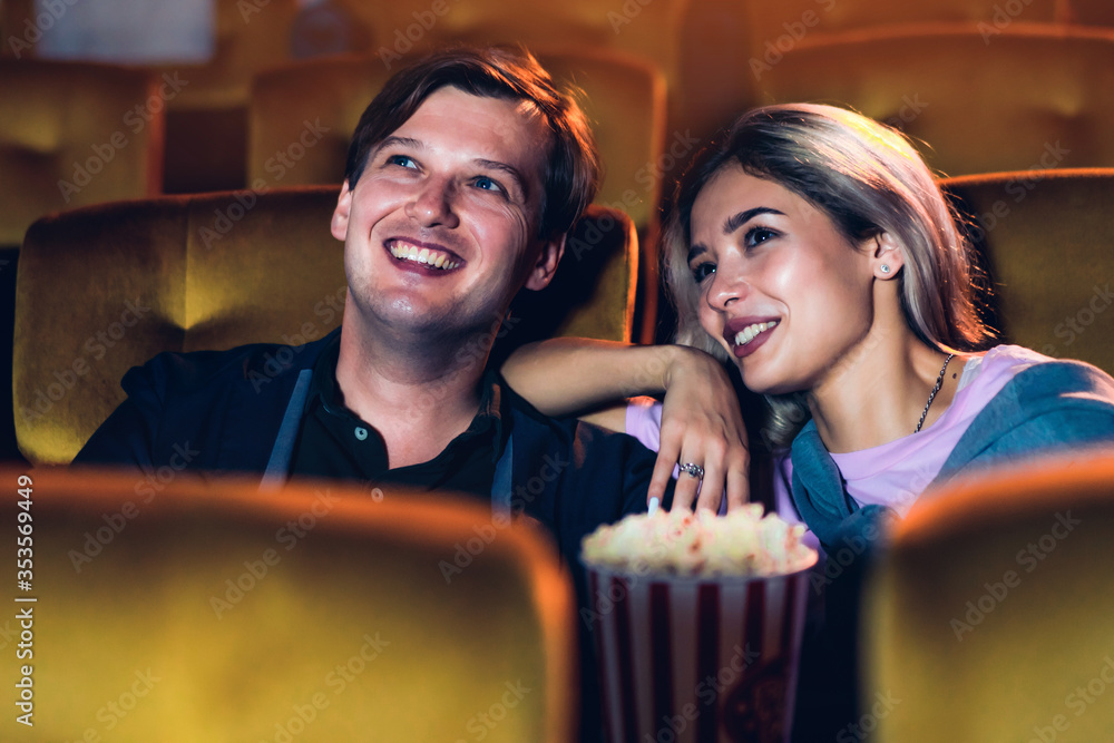 Caucasian lover enjoying to watch movie and eating popcorn together in the cinema