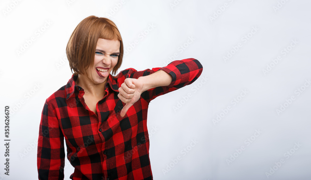 Girl shows finger down. Casual style woman portrait isolated over white background. Red haired lady 