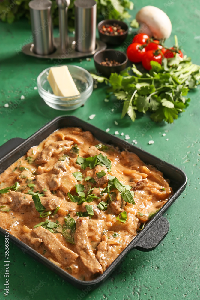 Tasty beef stroganoff on color background