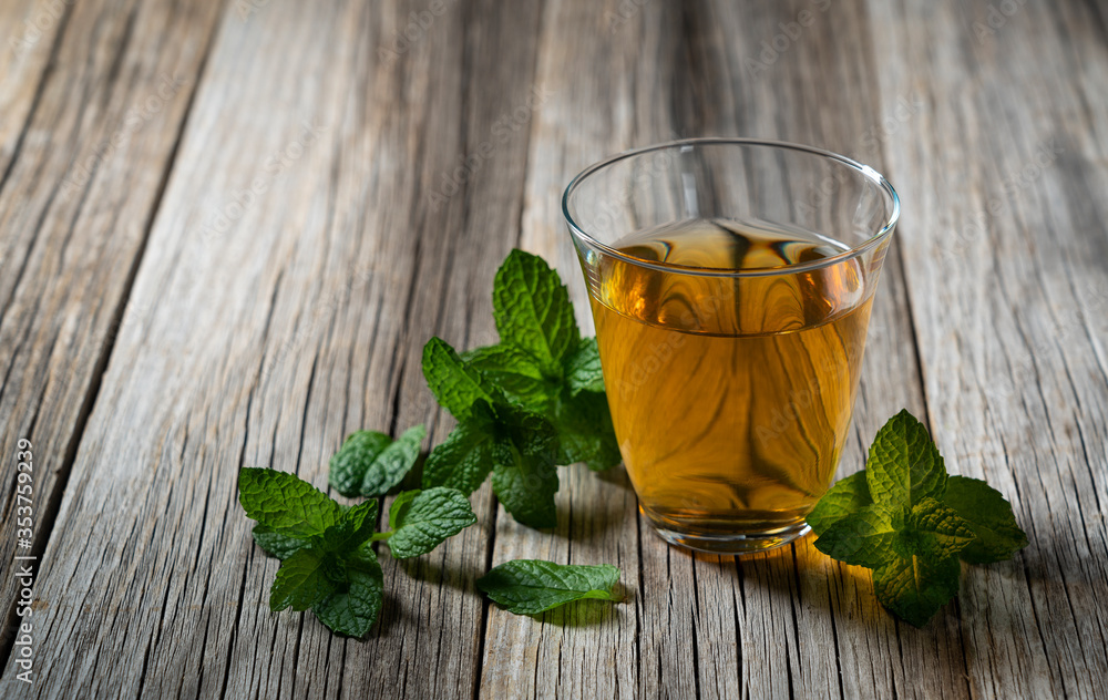 Mint tea and mint leaves set against the backdrop of an old tree