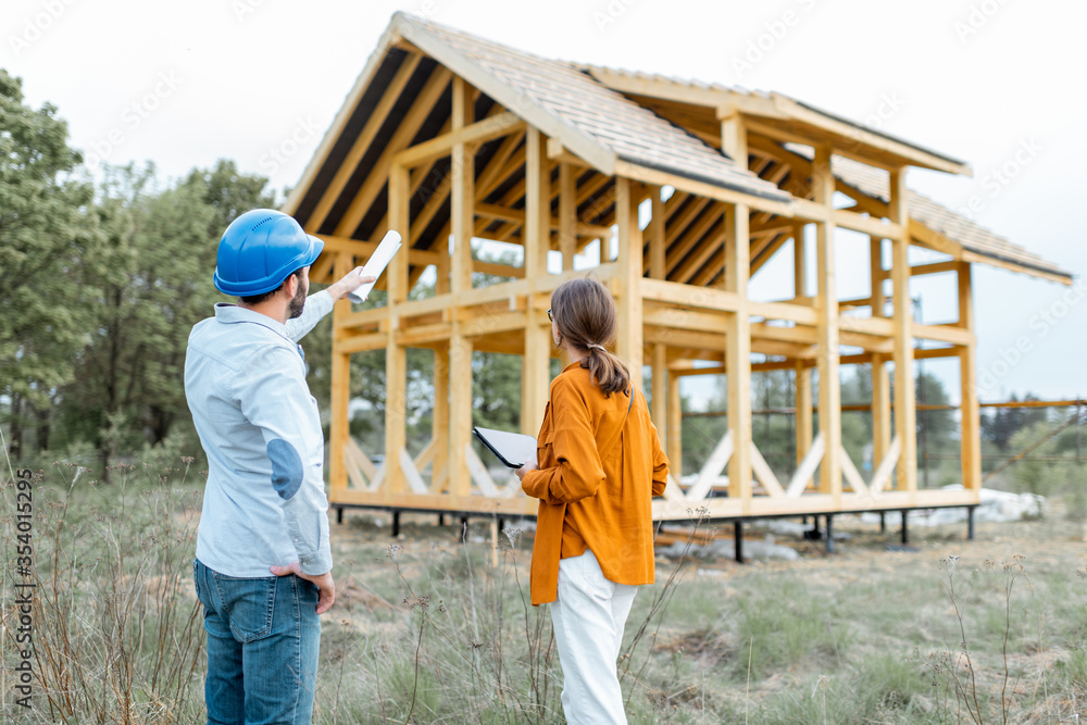 建筑工地户外木屋结构附近有一名女性客户的建筑工人。Buil