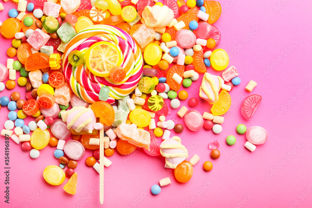 Assortment of sweet candies on color background