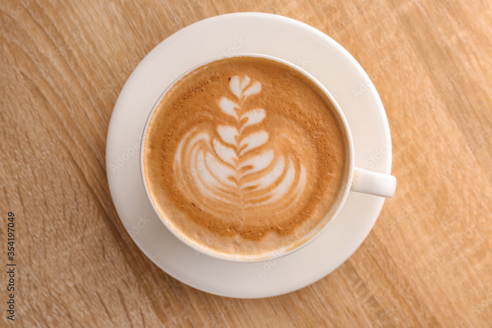 Cup of tasty coffee on wooden table