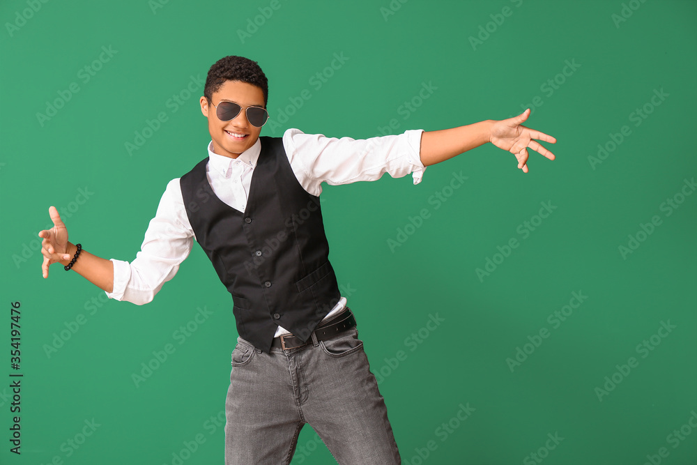 African-American teenager dancing against color background