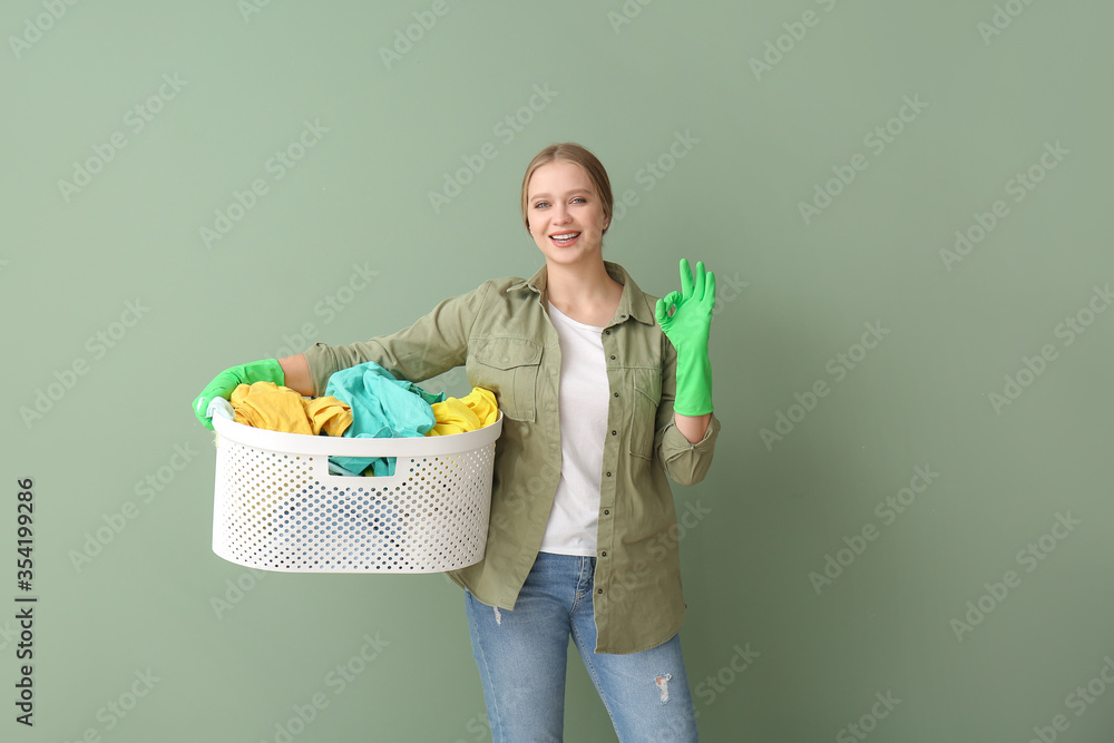 带着洗衣房的年轻女子在彩色背景上显示OK手势