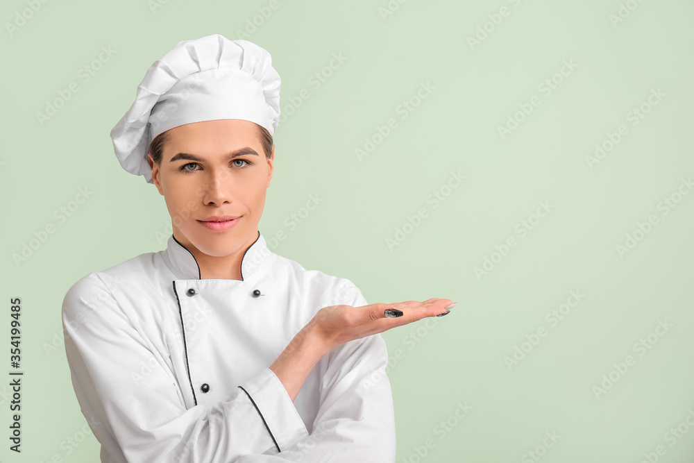 Transgender chef showing something on color background