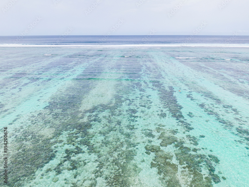 空中航行：女性浮潜者在绿松石海洋周围潜水，探索珊瑚礁