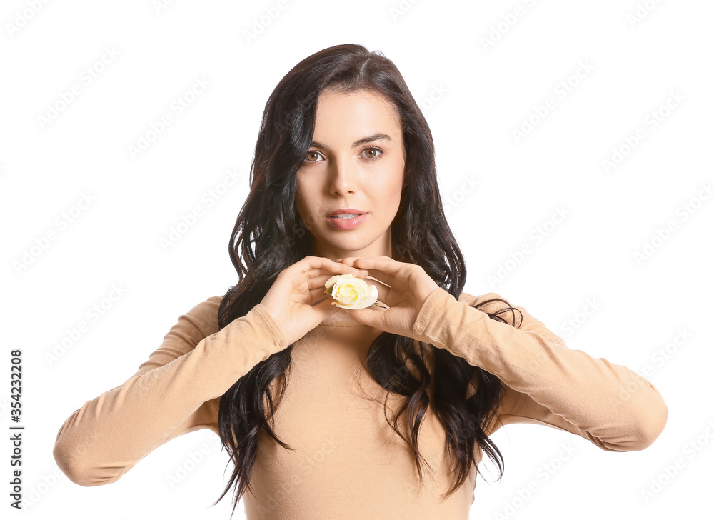 Beautiful young woman with rose on white background