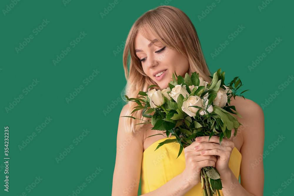 Beautiful young woman with bouquet of roses on color background