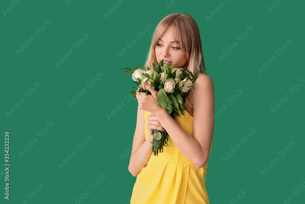 Beautiful young woman with bouquet of roses on color background