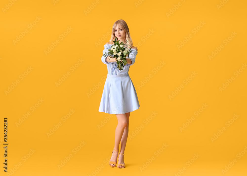 Beautiful young woman with bouquet of roses on color background