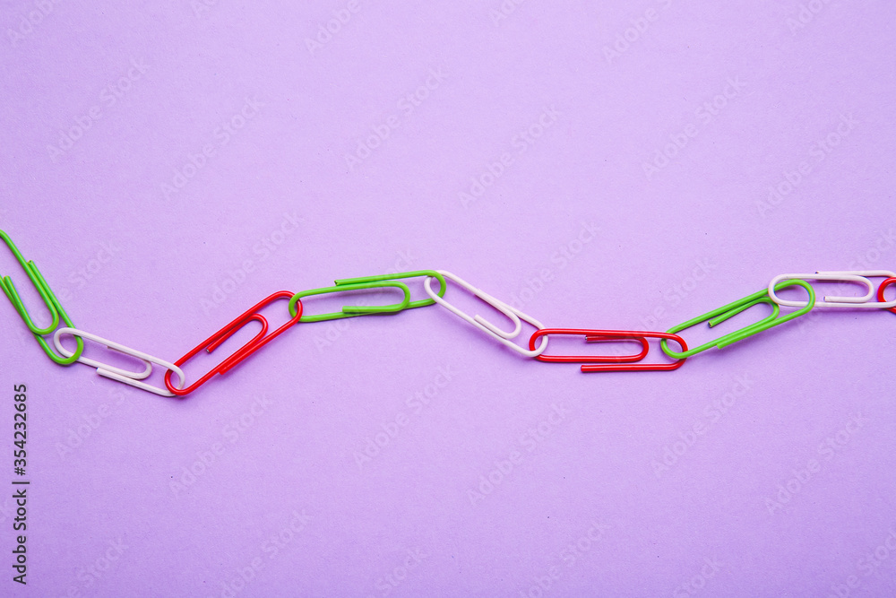 Paper clips on color background. Unity concept