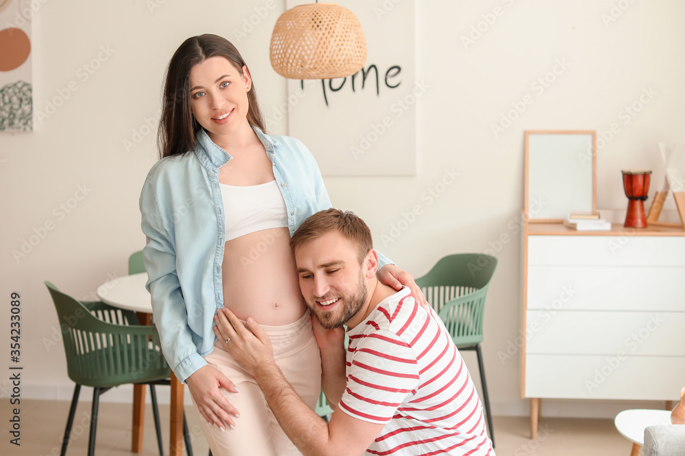 Beautiful pregnant woman with her husband at home