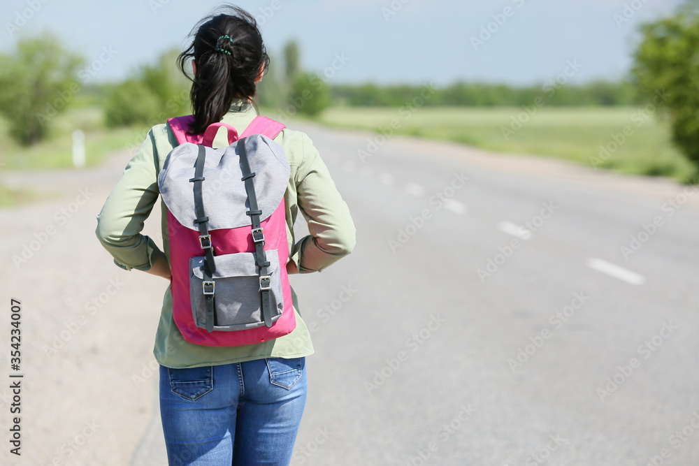 背着背包的女性旅行者在路上行走