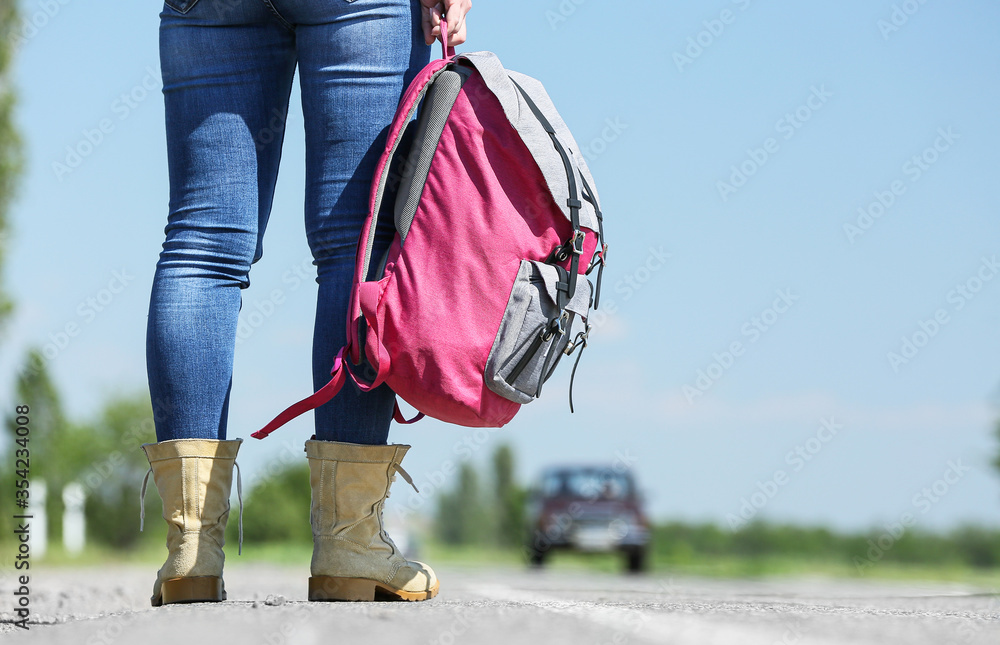 背着背包站在路上的女性旅行者