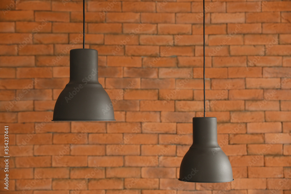 Hanging lamps against brick wall