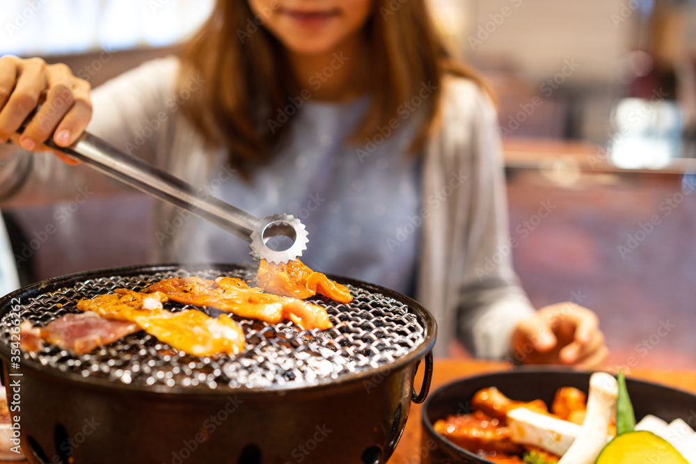 亚洲年轻人在餐厅吃韩国烤肉