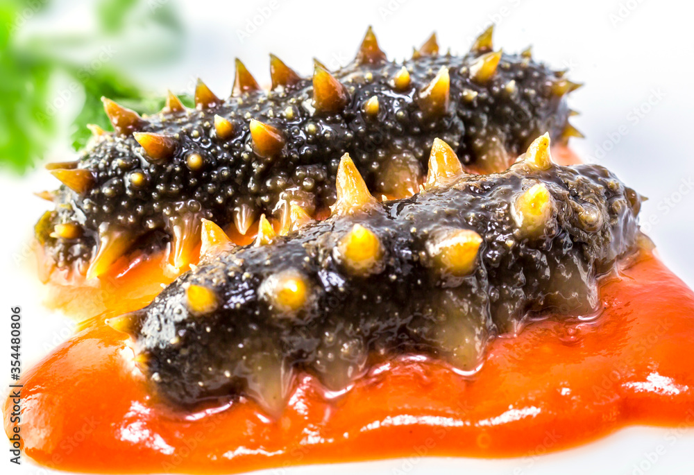 Sea cucumber with tomato sauce on white background