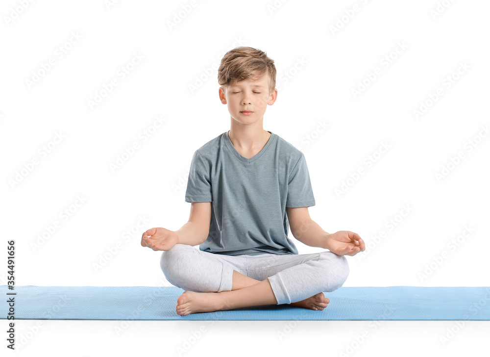 Cute little boy practicing yoga on white background