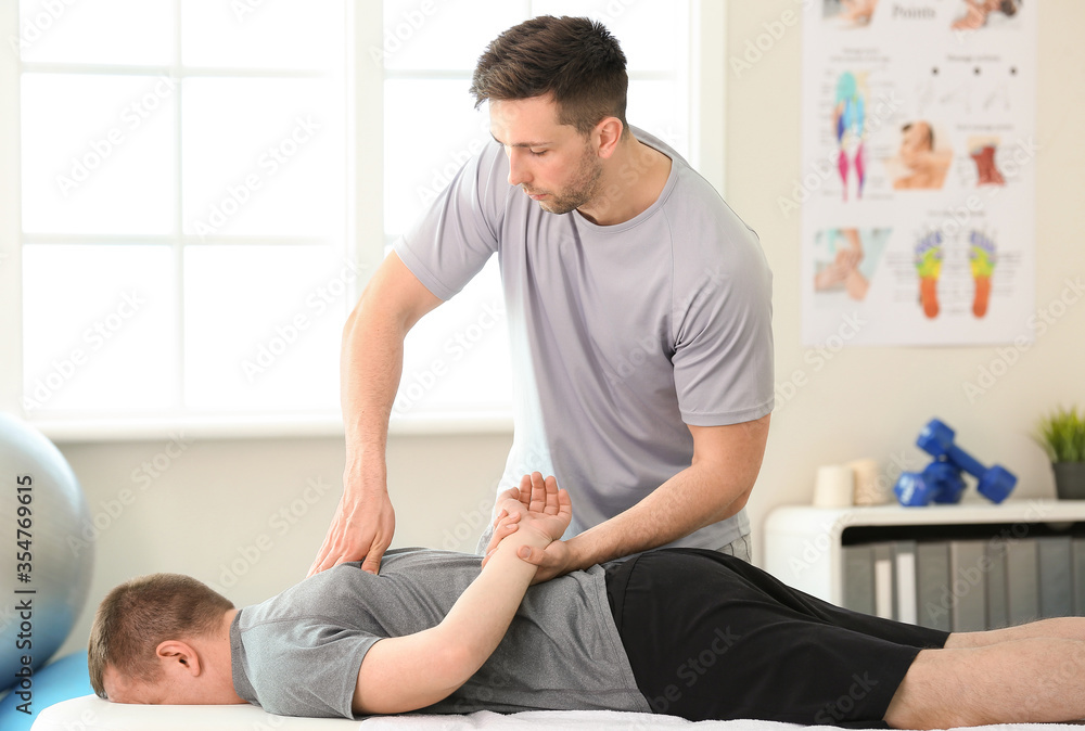 Massage therapist working with patient in medical center