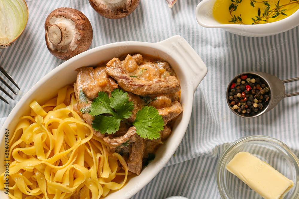 Tasty beef stroganoff with pasta on table