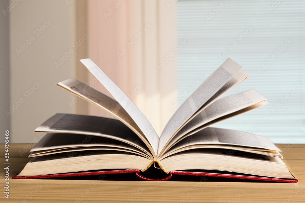 Open book on old wooden table.