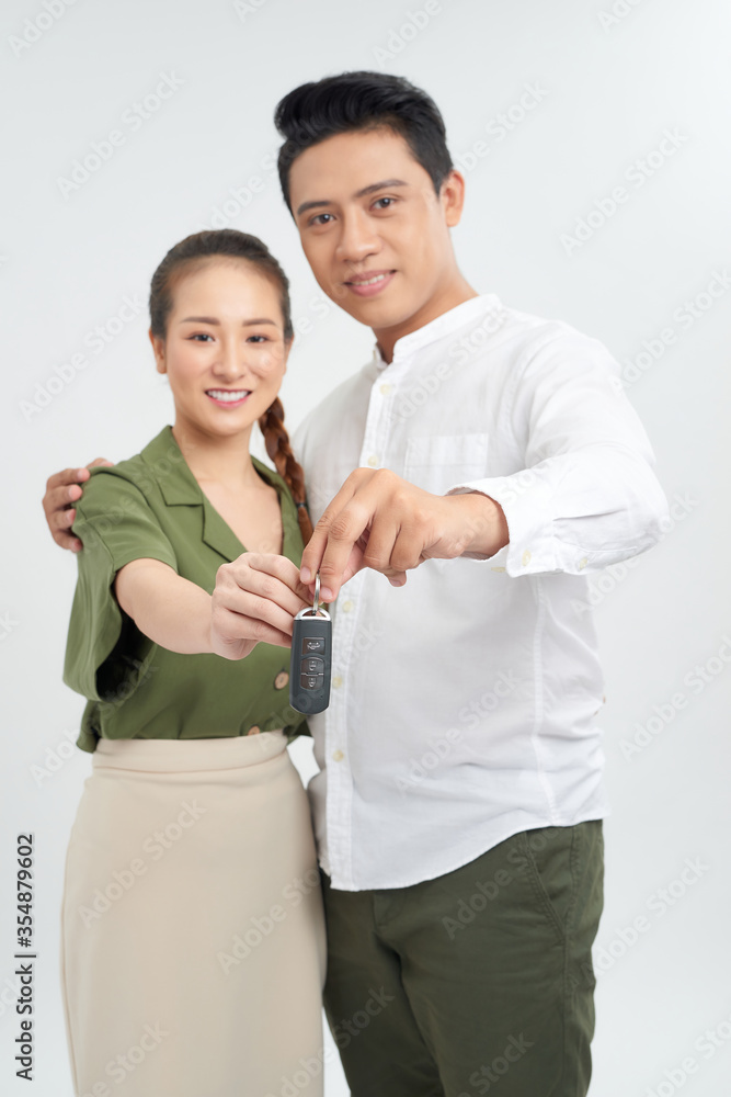 Car key hold smiling young couple in studio background