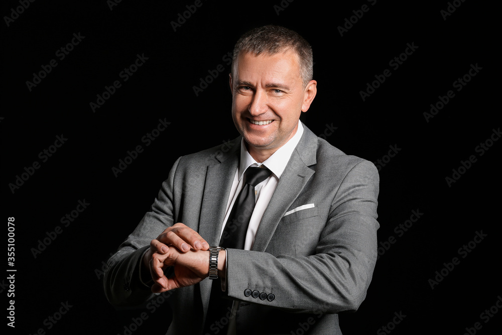 Portrait of handsome businessman on dark background