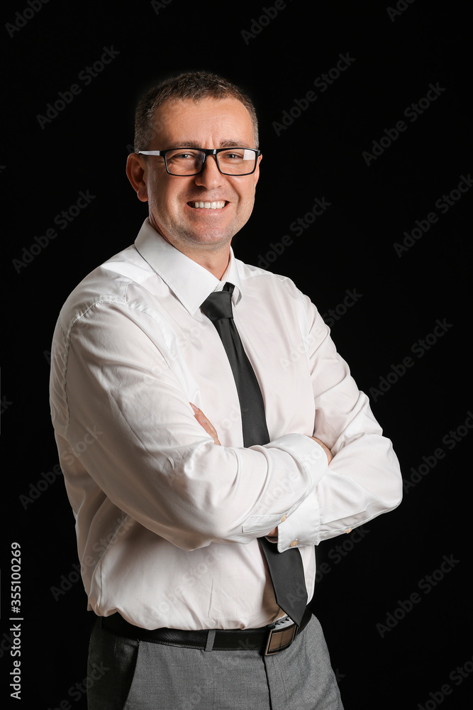 Portrait of handsome businessman on dark background