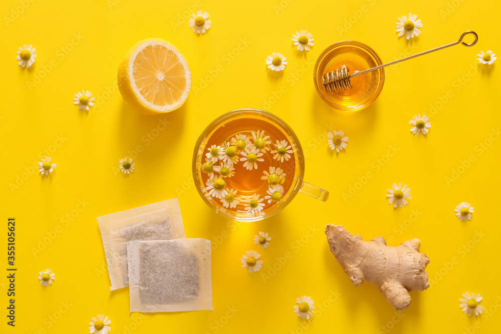 Chamomile tea with honey, lemon and ginger on color background