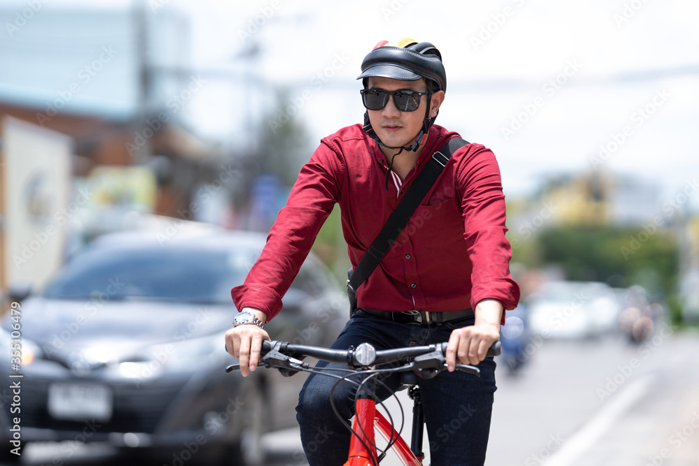 Asian men riding bicycles on the road to work in the morning.