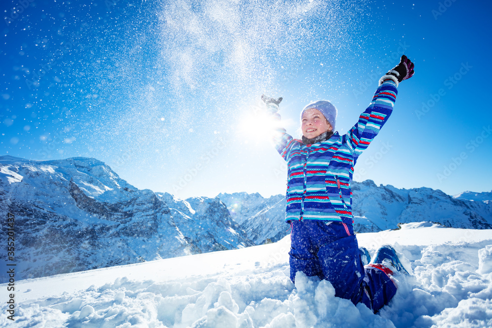 动作动态肖像滑雪女孩站在山顶向空中扔雪