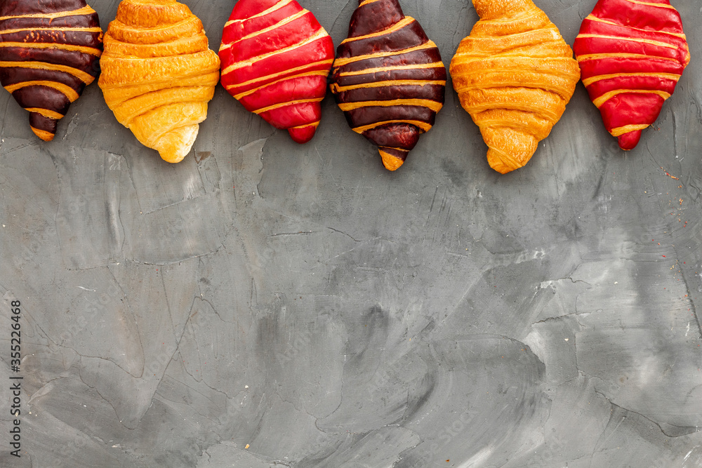 Frame of croissants - fresh bakery on dark stone background. Top view