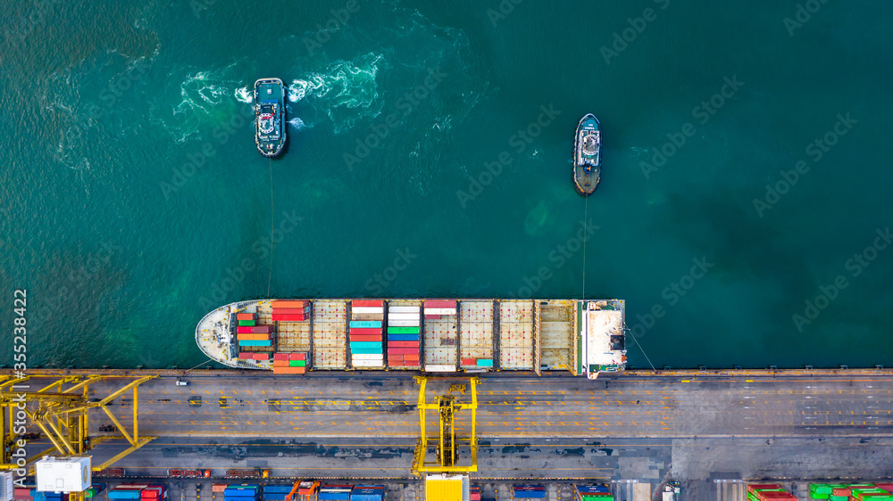 Aerial top view container ship at terminal seaport with tugboat, Global business cargo freight ship 