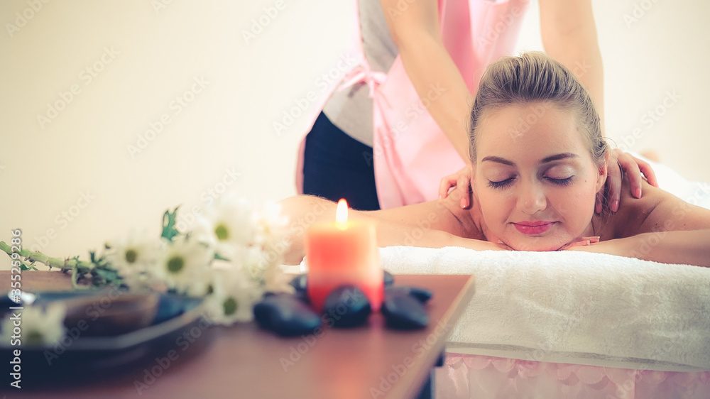 Relaxed woman getting back massage in luxury spa with professional massage therapist. Wellness, heal