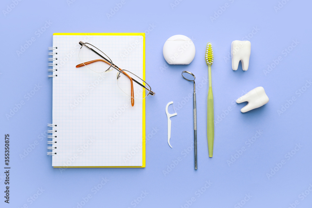 Set for oral hygiene with notebook and eyeglasses on color background