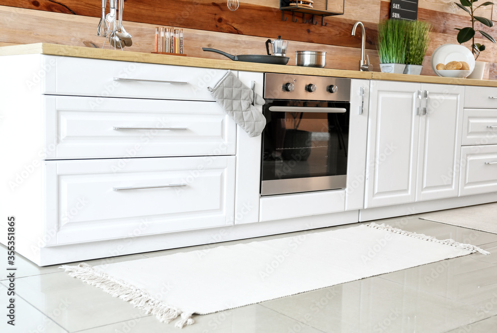 Stylish carpet on floor in modern kitchen