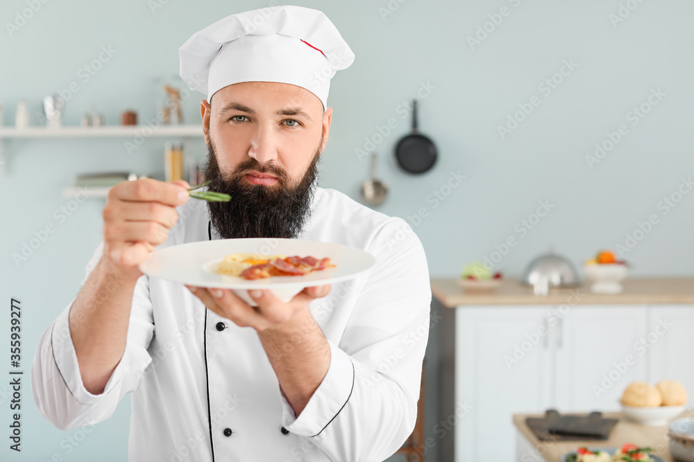 Male chef with tasty pasta carbonara in kitchen