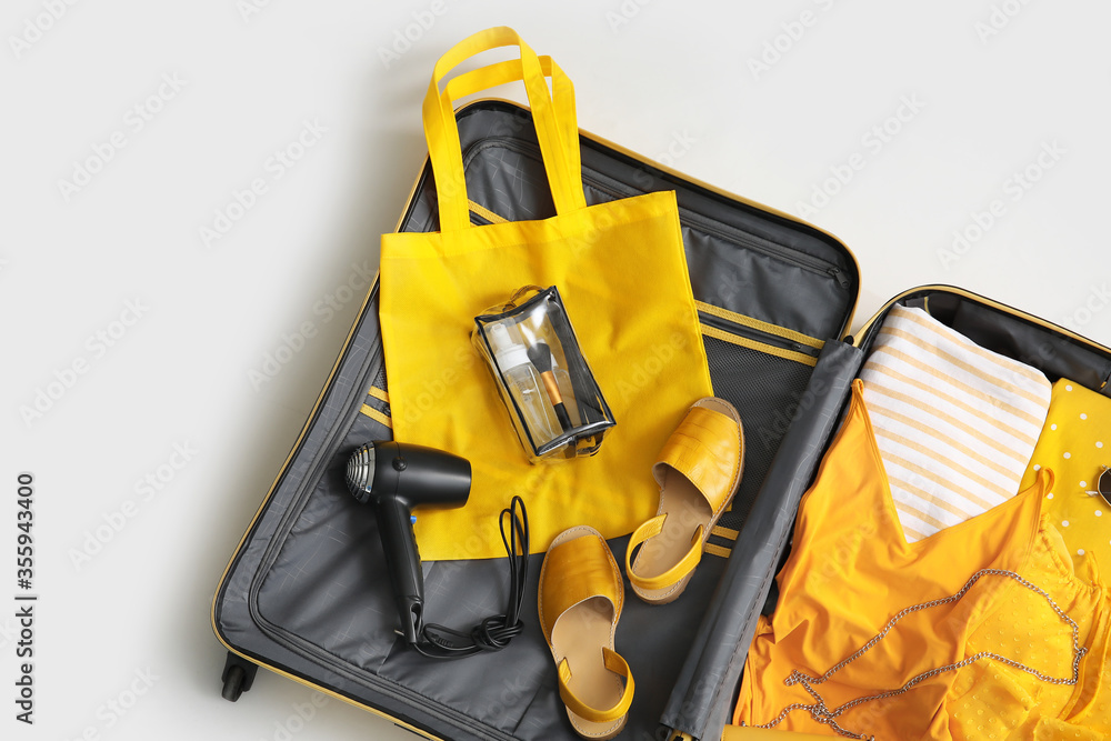 Open packed suitcase on white background