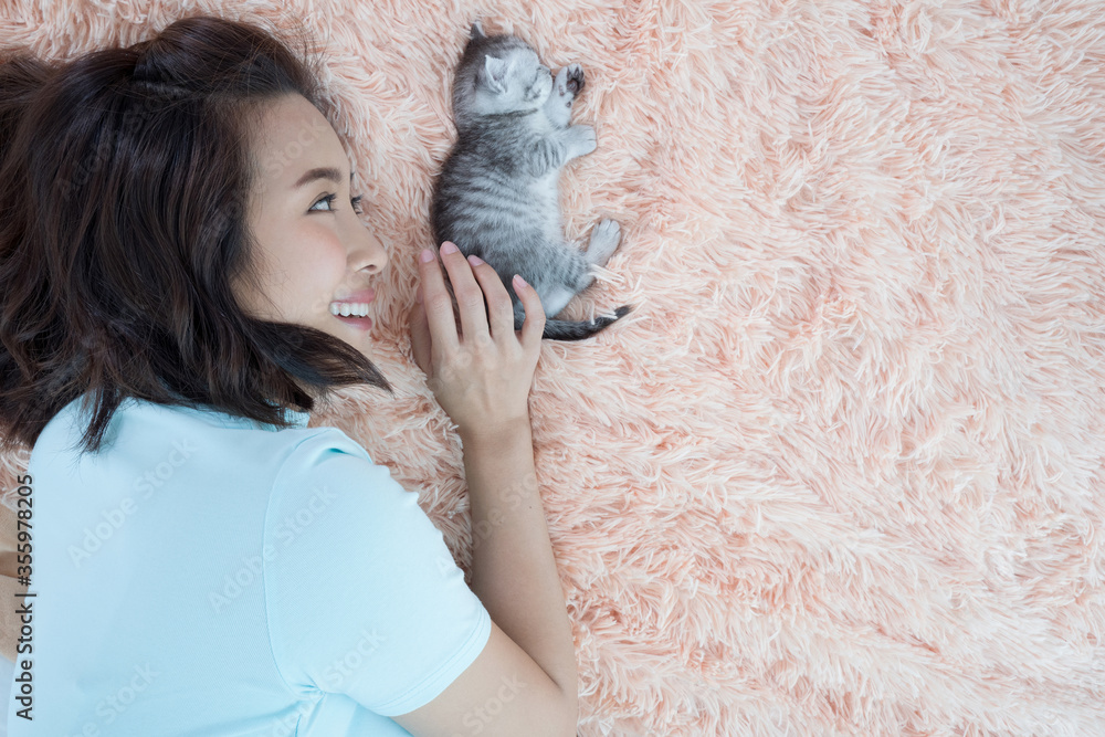 Young Asian woman with kitten cat pet sleep on the bed