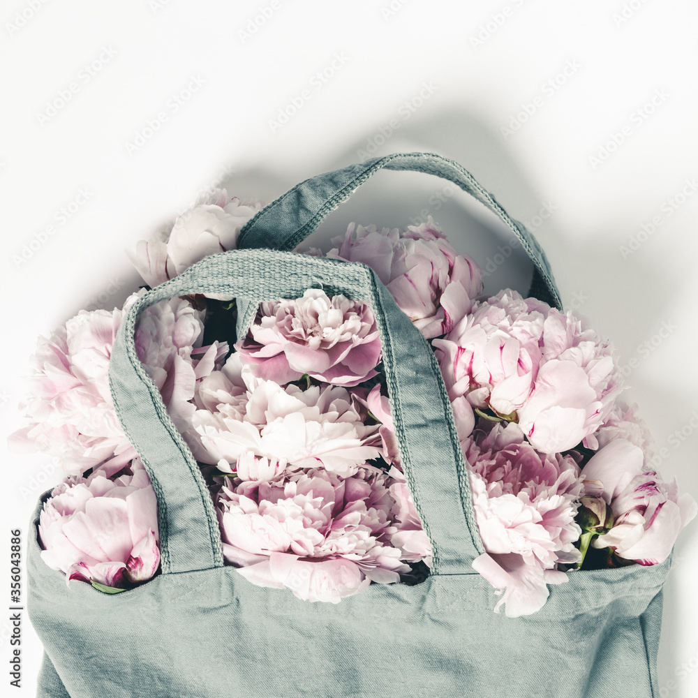 Blue cotton eco tote bag with peony flowers on white background with copy space