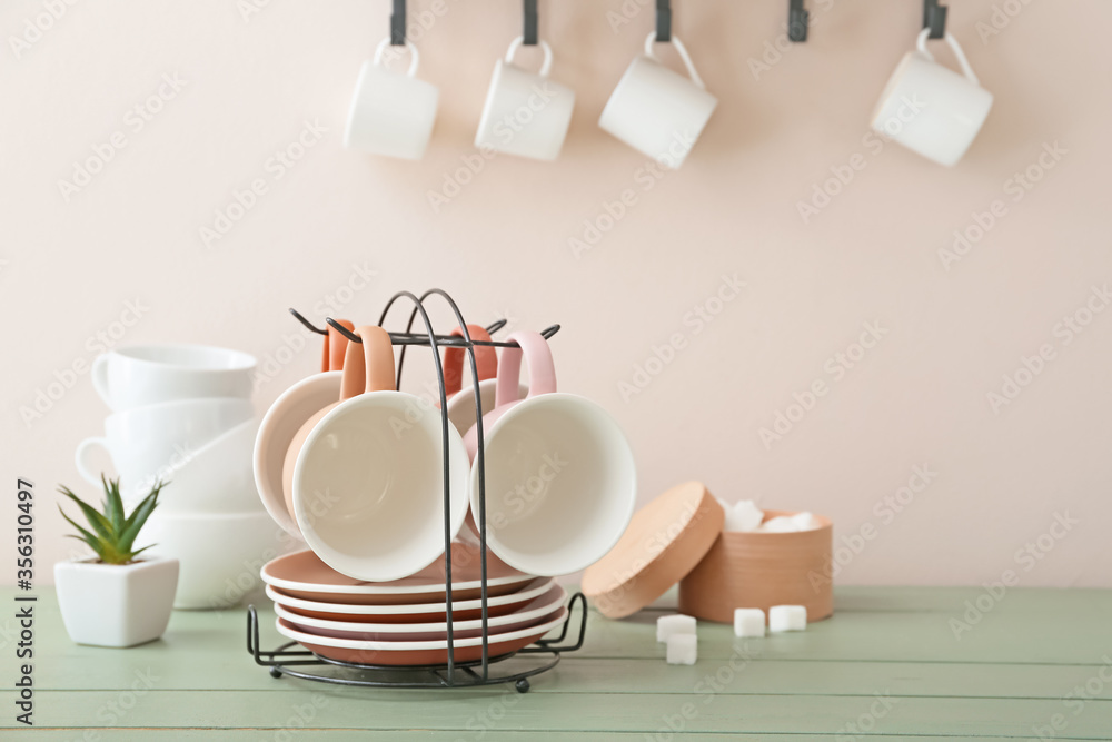 Holder with cups and saucers on kitchen table