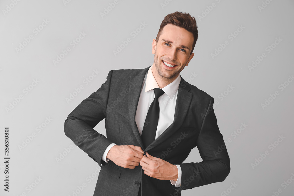 Portrait of handsome businessman on grey background