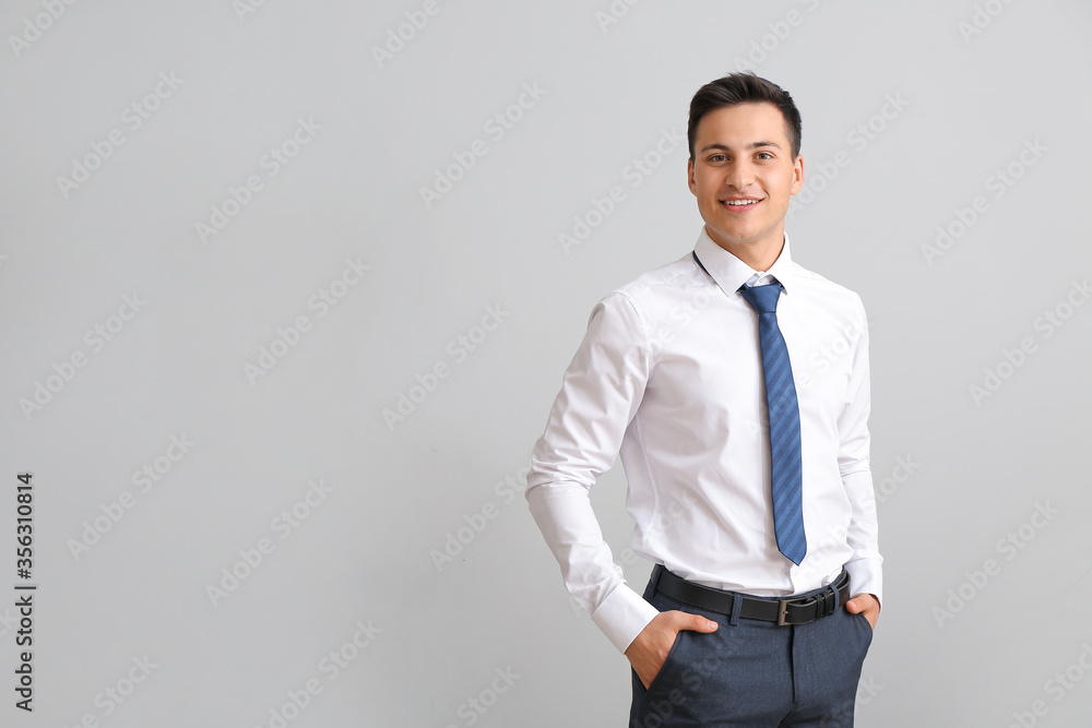 Portrait of handsome businessman on grey background