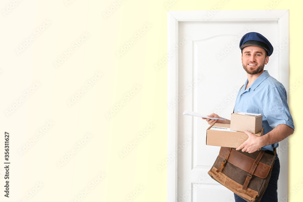 Handsome young postman near door