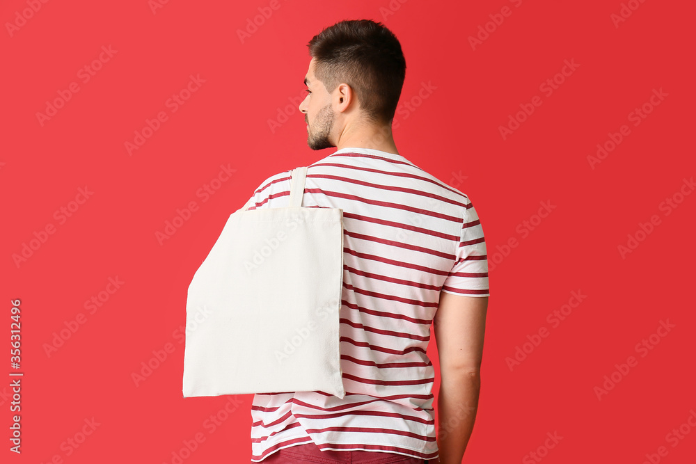 Young man with eco bag on color background