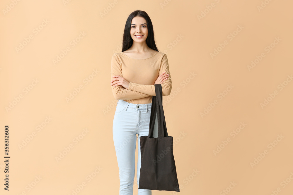 Young woman with eco bag on color background